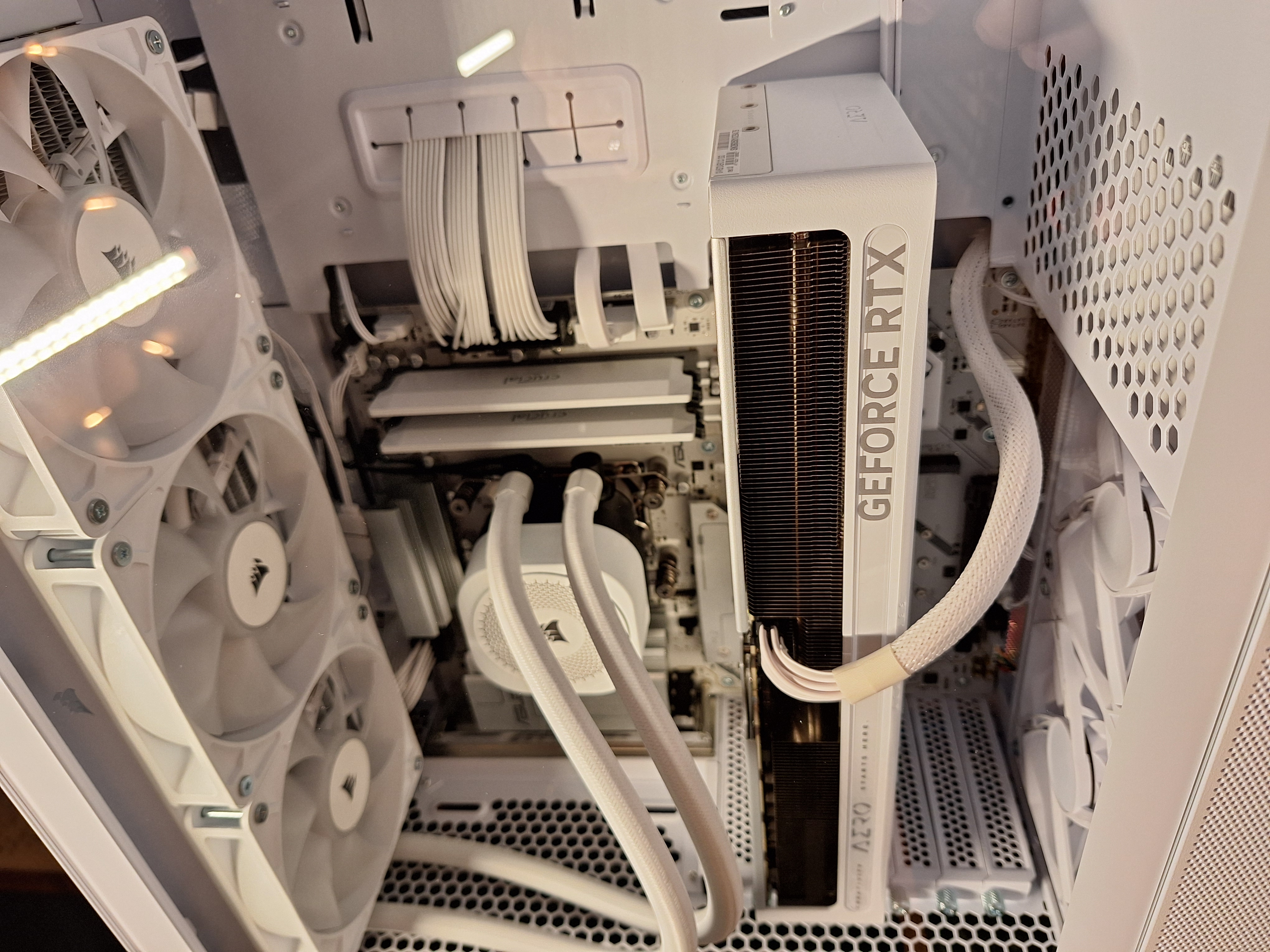 Angled close-up of the white GeForce RTX graphics card, liquid cooler, and cable routing